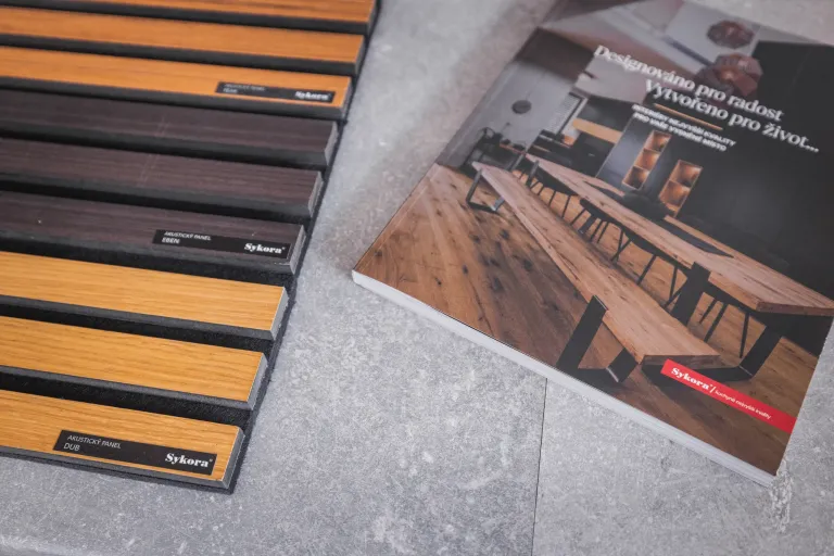 Vzorník dřevěných dekorů a katalog kuchyňského studia na šedém povrchu