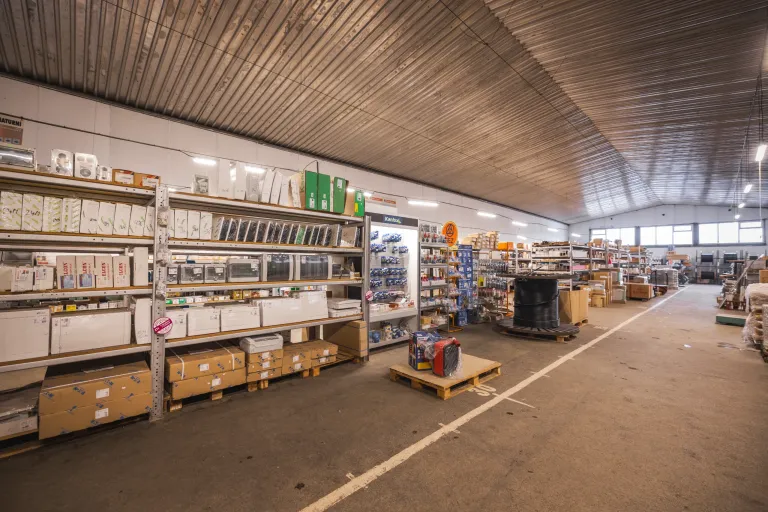 Interiér velkoobchodu s elektroinstalačním materiálem na regálech a paletách