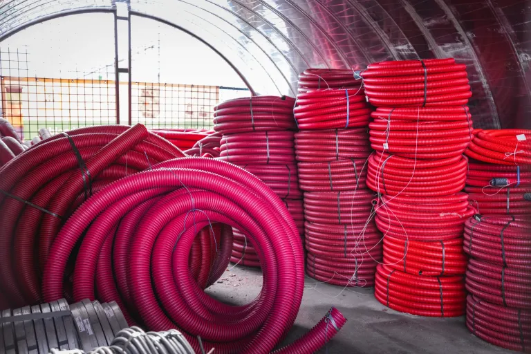 Hromady červených elektroinstalačních chrániček v roli ve skladu velkoobchodu elektro