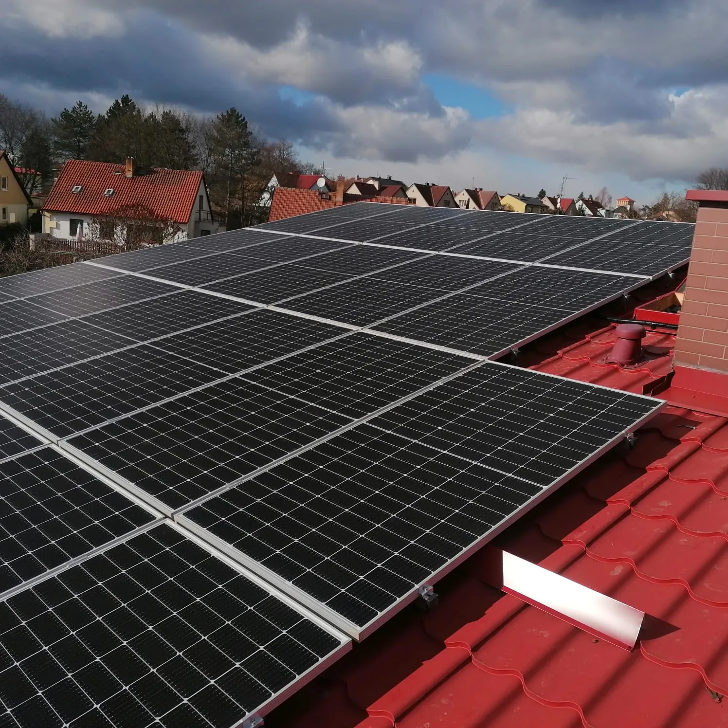Fotovoltaické panely na červené střeše rodinných domů