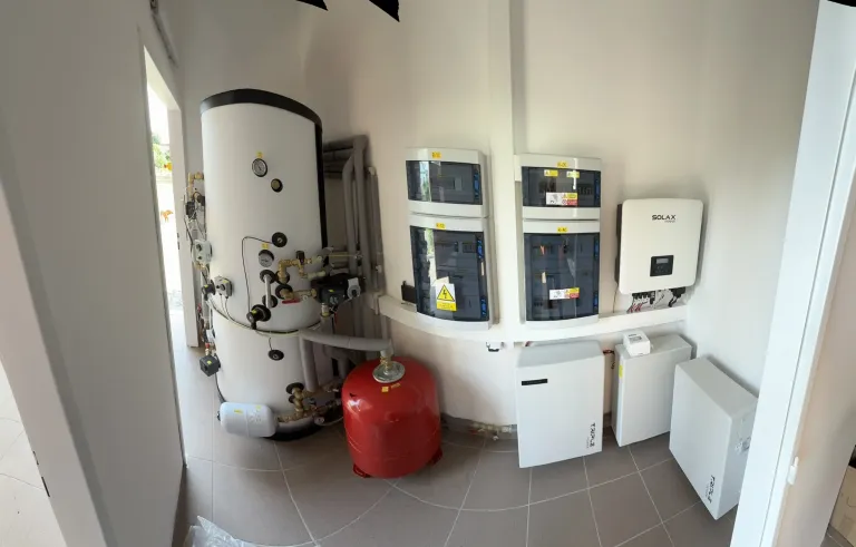 Střídače fotovoltaiky a akumulační nádrž v technické místnosti