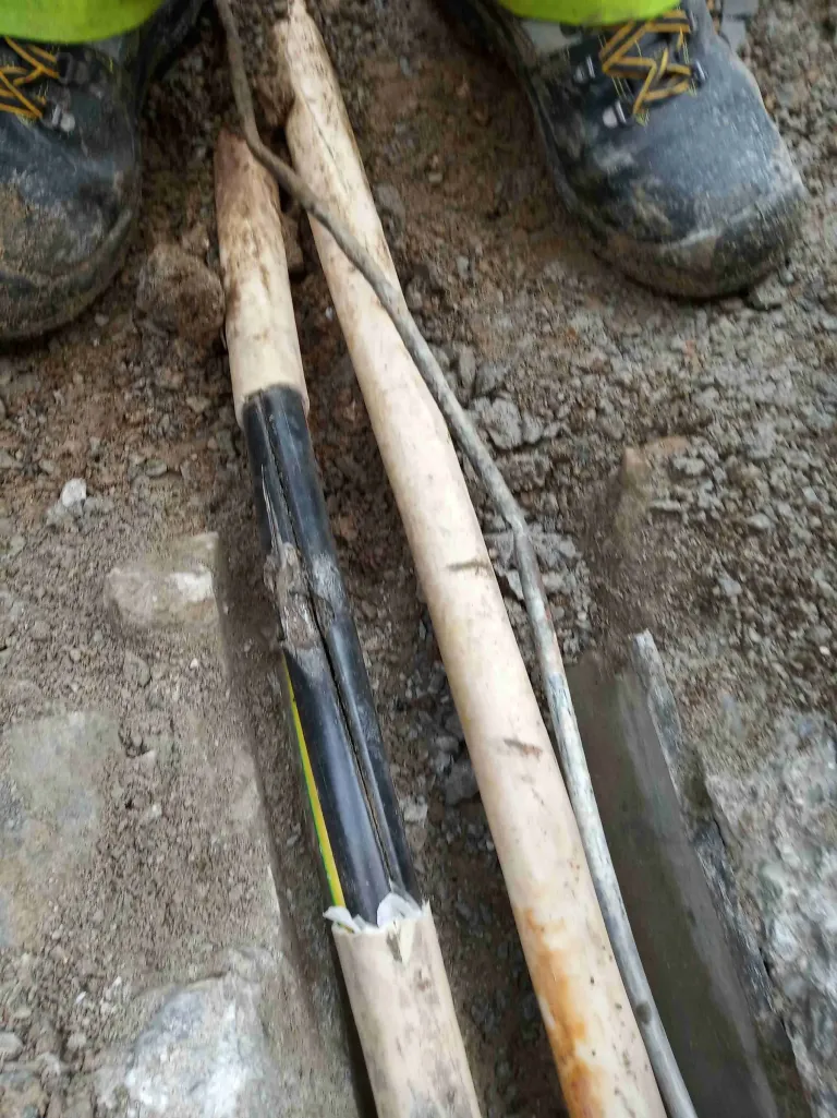 Uložený kabel v úzkém výkopu před zásypem