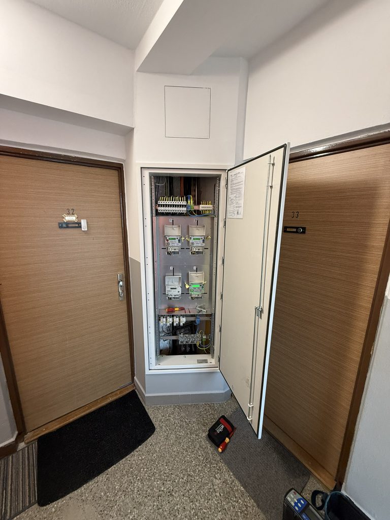 Patrový rozvaděč s elektroměry a jističi ve společné chodbě bytového domu