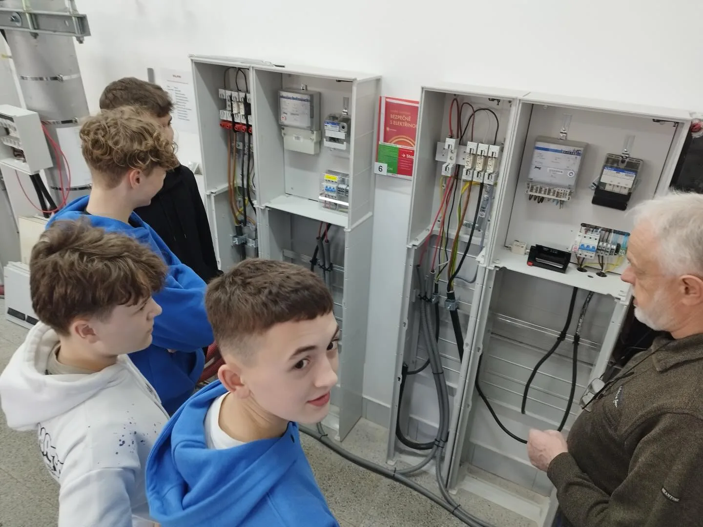 Technik vysvětluje funkci elektrických rozvaděčů skupině žáků ve výukovém polygonu