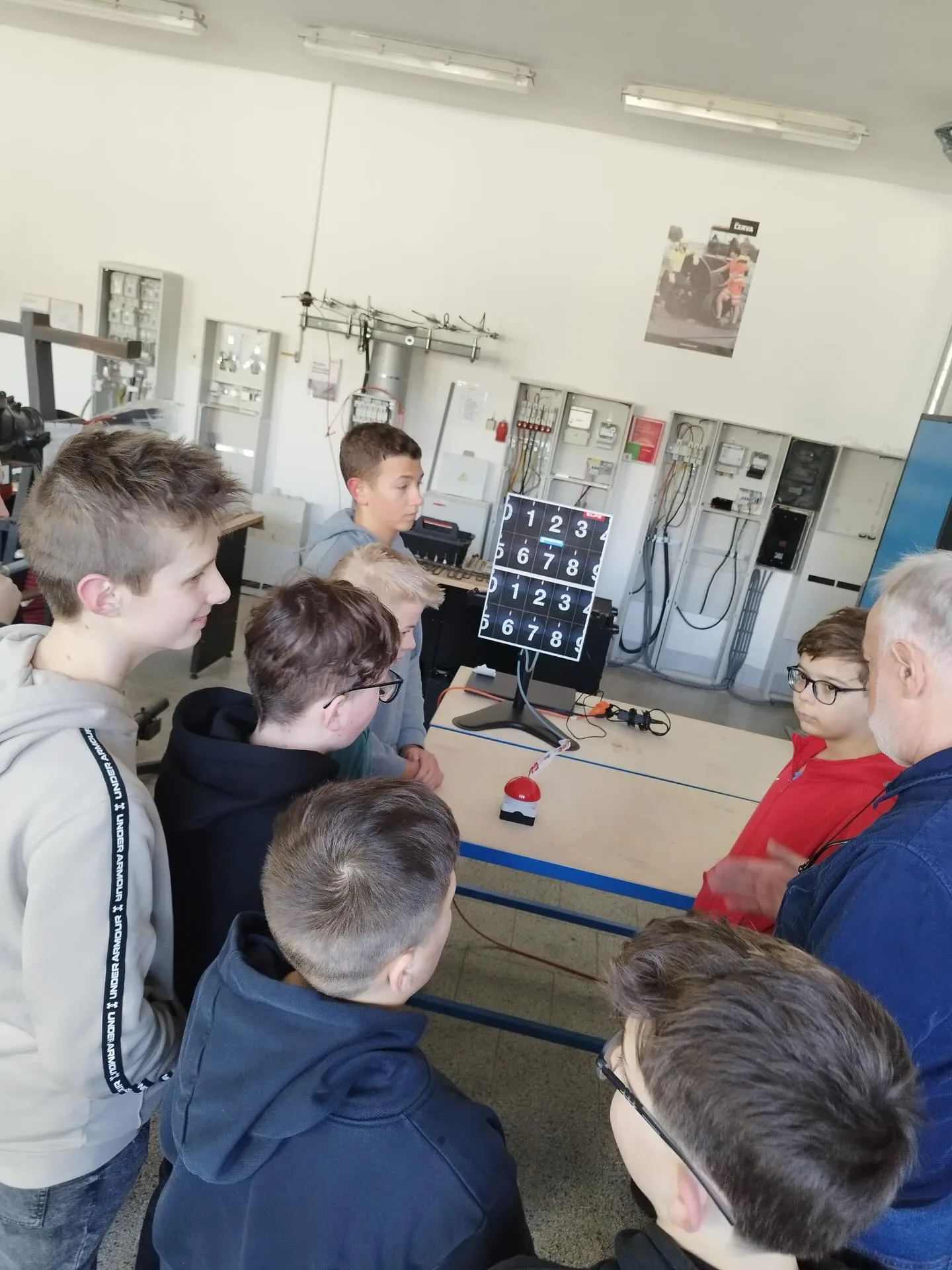 Technik vysvětluje žákům funkci výukového panelu v učebně ELPE