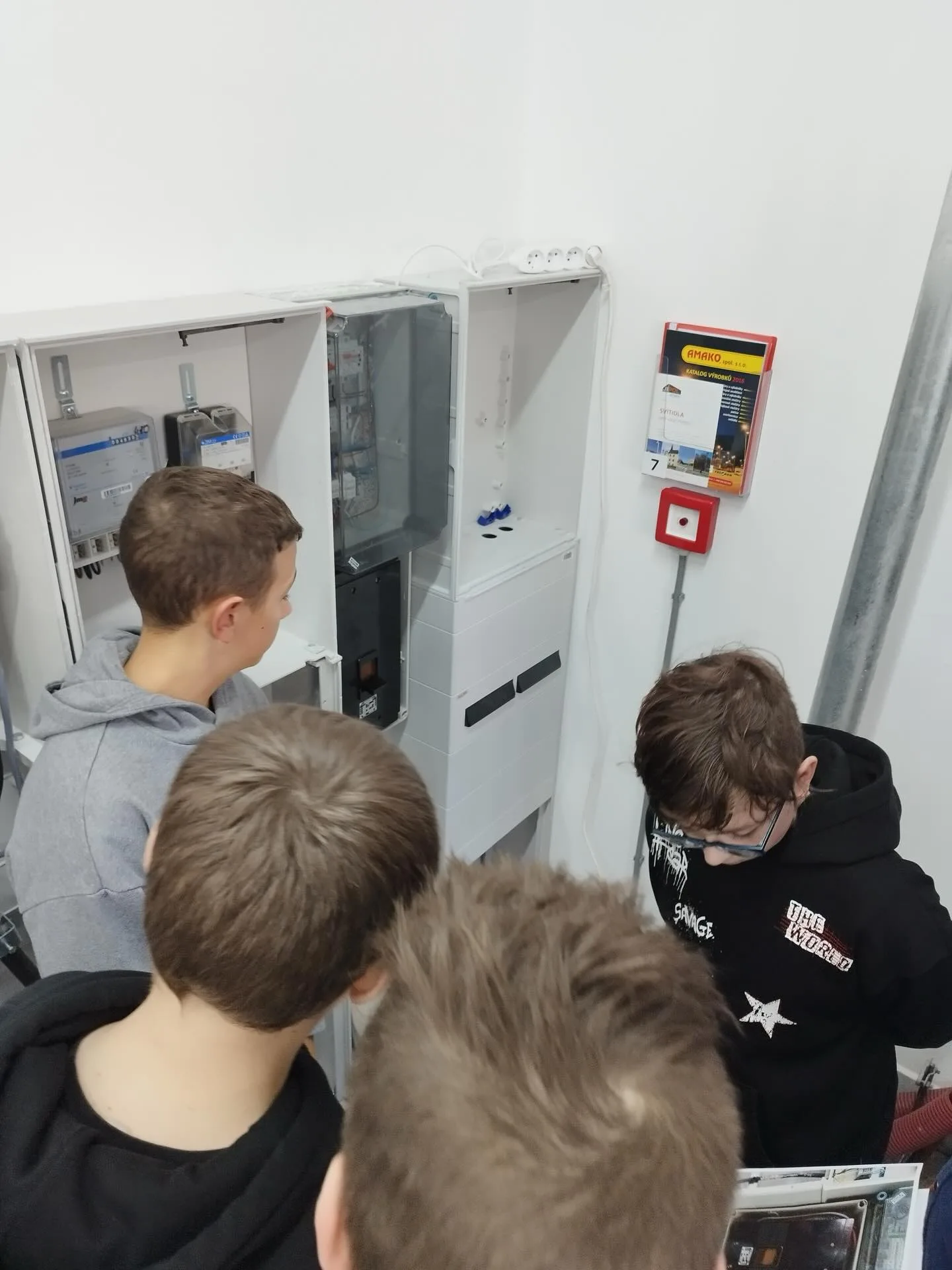 Skupina žáků u otevřených rozvaděčových skříní ve výukovém polygonu ELPE