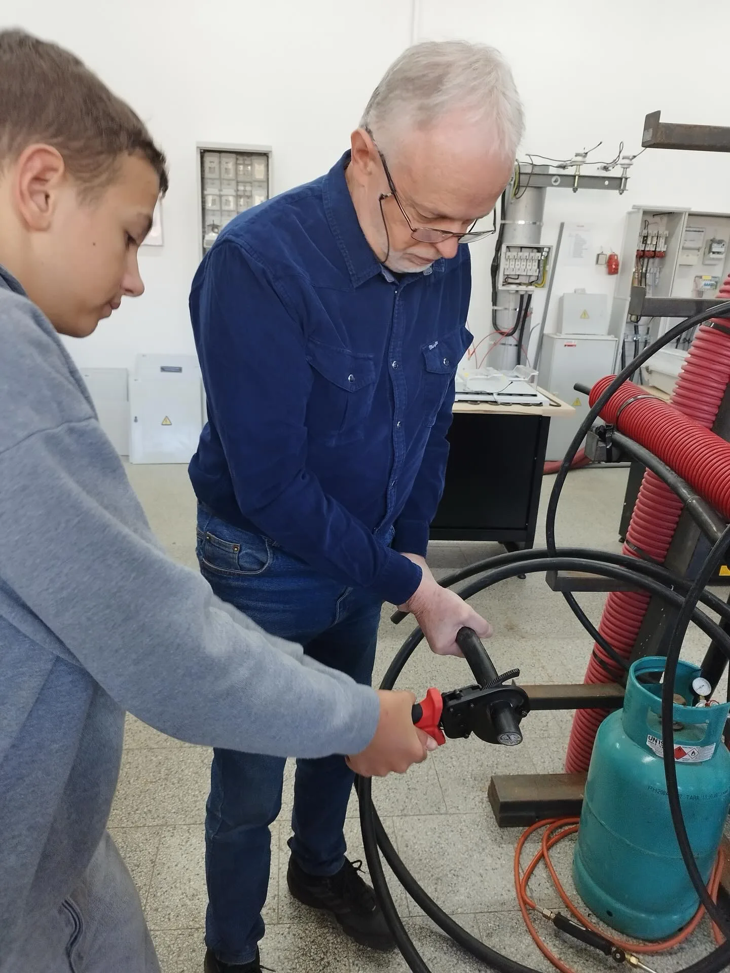 Technik a žák pracují s elektrickým nářadím v dílně ELPE