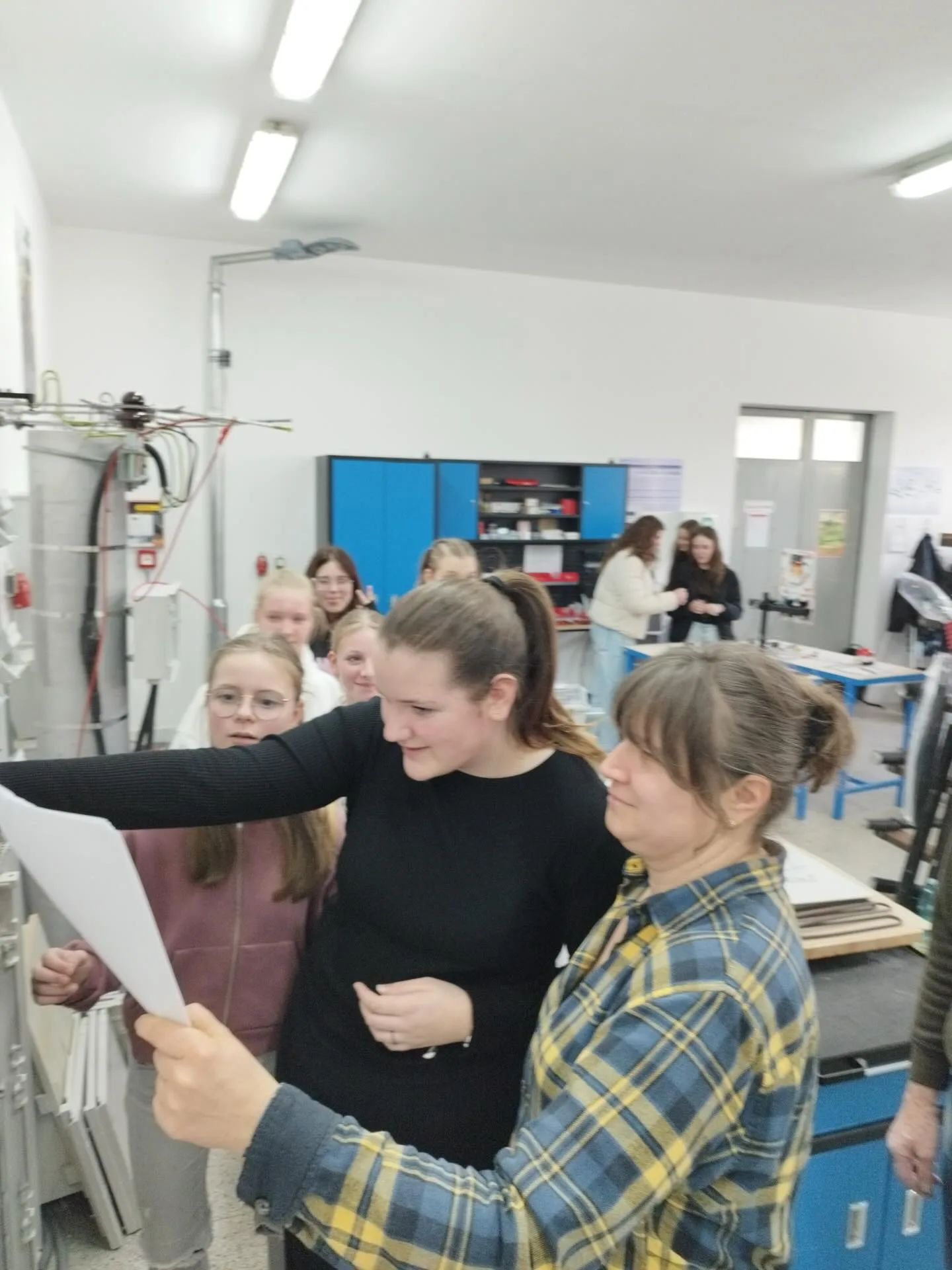 Žákyně si prohlížejí technický výkres během projektového dne ve škole