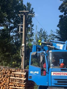 Technik kontroluje stožár nadzemního vedení z montážní plošiny firmy ELPE