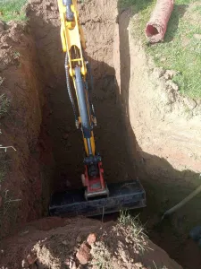 Pásové rypadlo hloubí kabelovou rýhu v terénu pro elektrotechnické práce