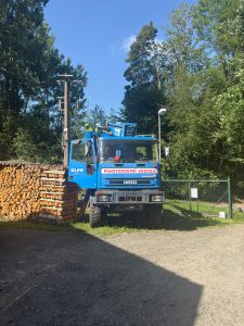 Pohotovostní vozidlo ELPE s montážní plošinou u stožárové trafostanice v lesním prostředí